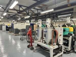 Photograph showing a row of Injection moulding machines and material driers in the new Termate Injection Moulding Facility